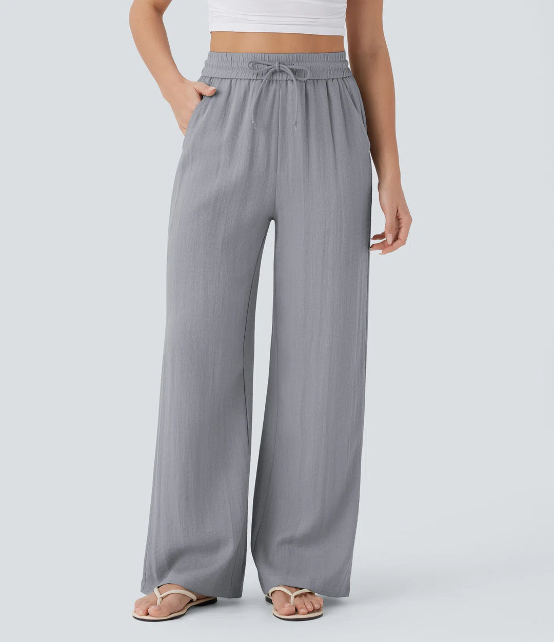 Pantalon large fluide taille haute avec cordon de serrage, poches latérales et aspect lin