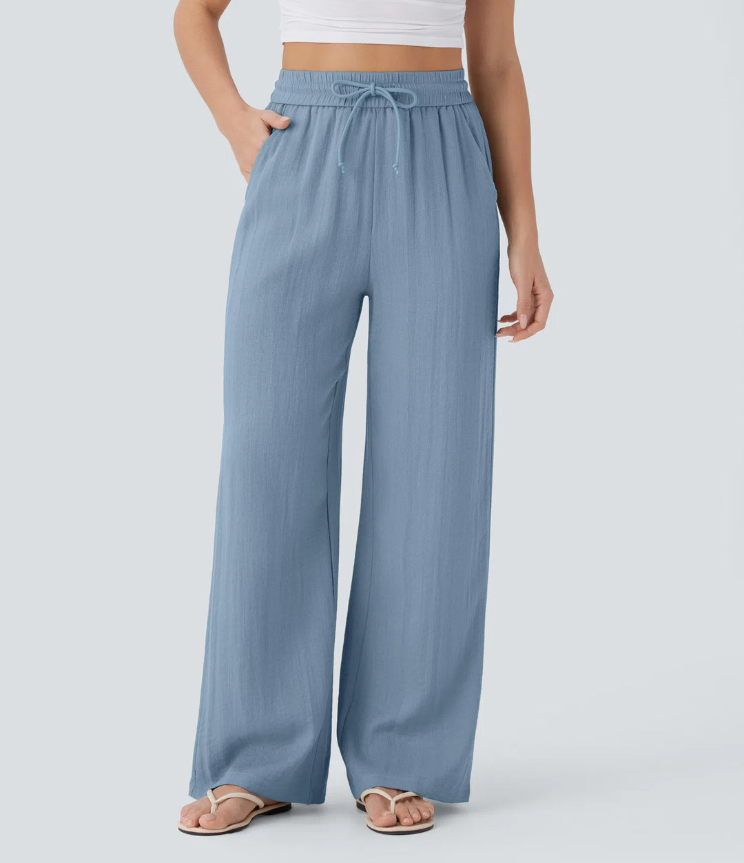Pantalon large fluide taille haute avec cordon de serrage, poches latérales et aspect lin